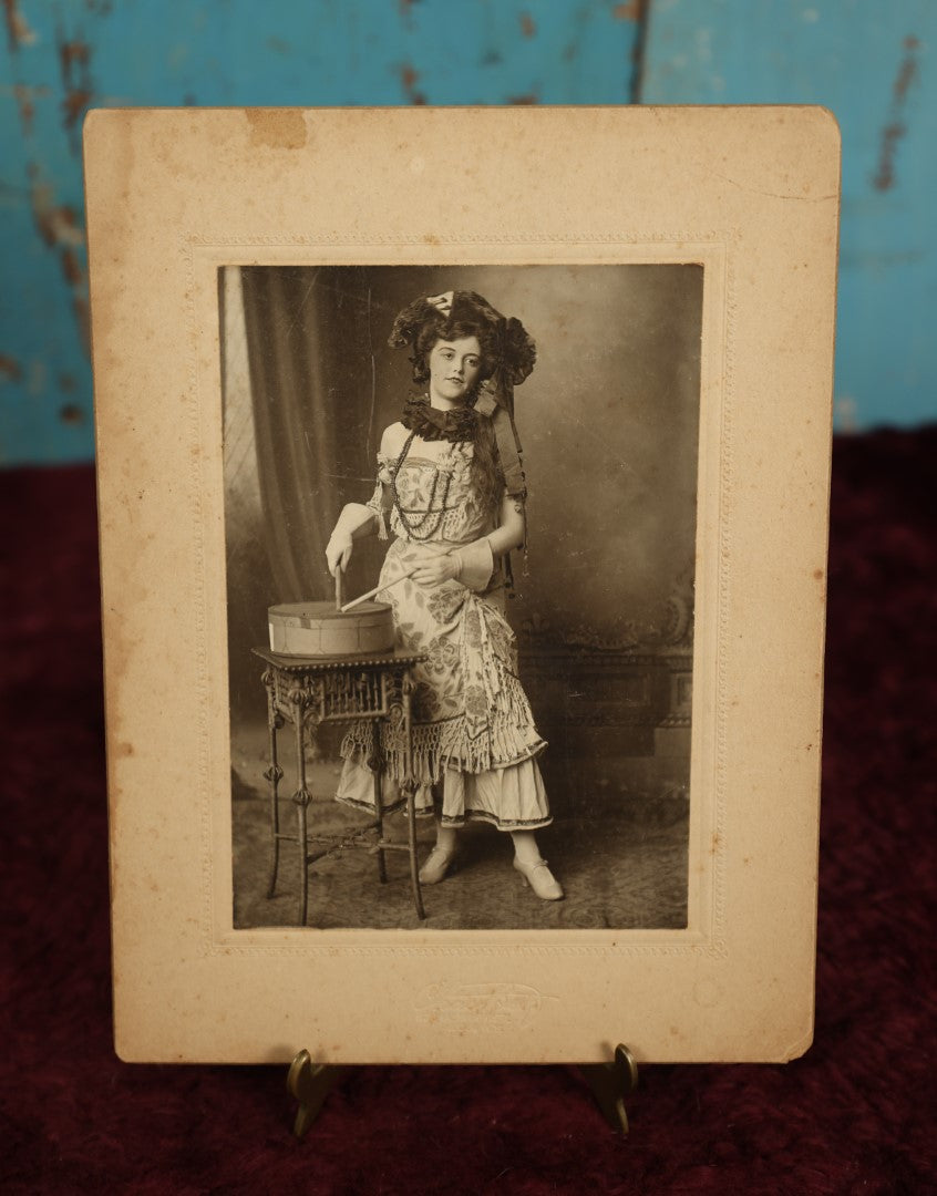 Lot 068 - Antique Boarded Photo Of Pretty Woman With Elaborate Costume, Drumming, Photographed By Charles "Chas" Betz Of Louisville, Kentucky, "Love To Mama And Papa From Florence," Writing On Back