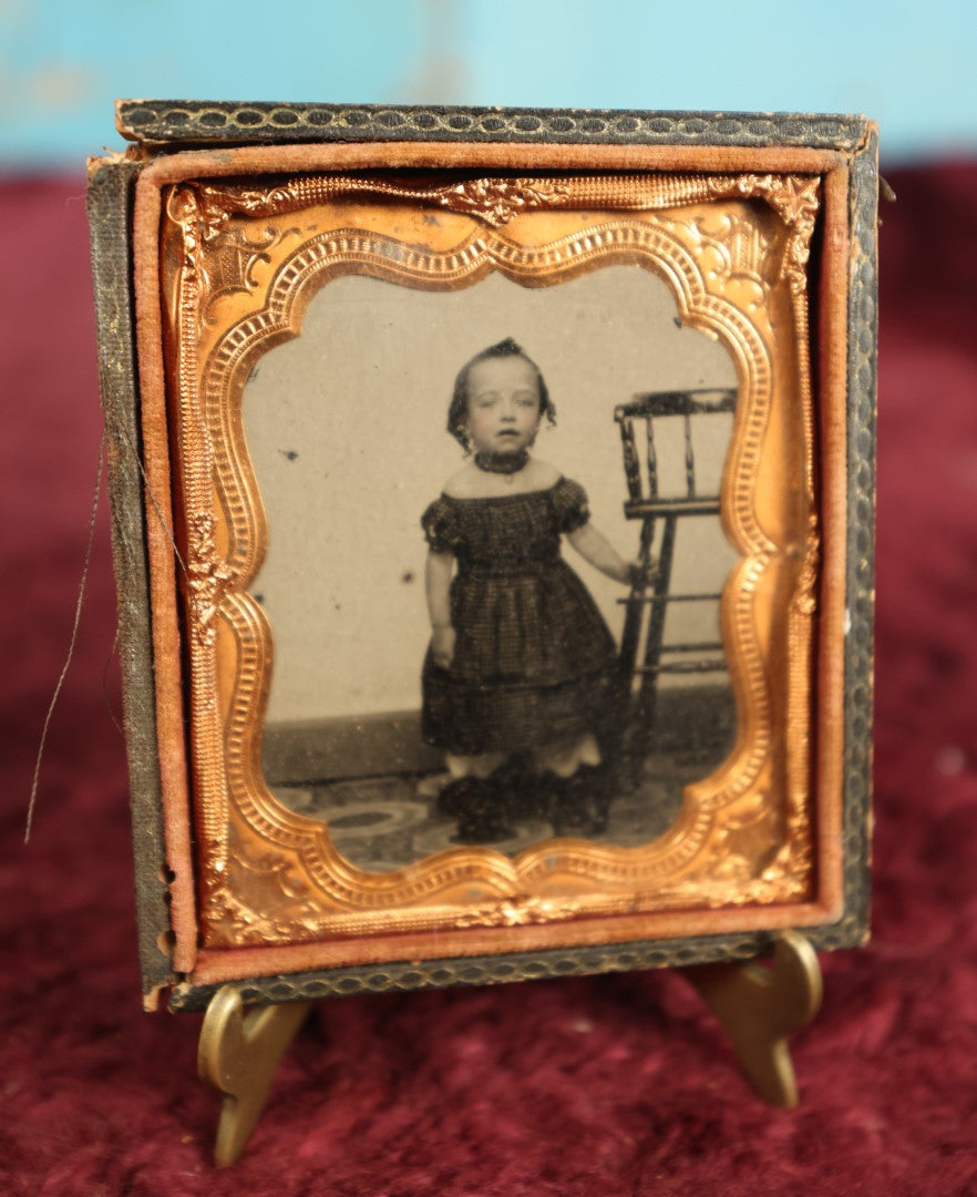 Lot 073 - Antique 1/6th Plate Ruby Ambrotype Of Young Girl Toddler Holding High Chair, Dark Off The Shoulders Dress, Heavy Wear To Case