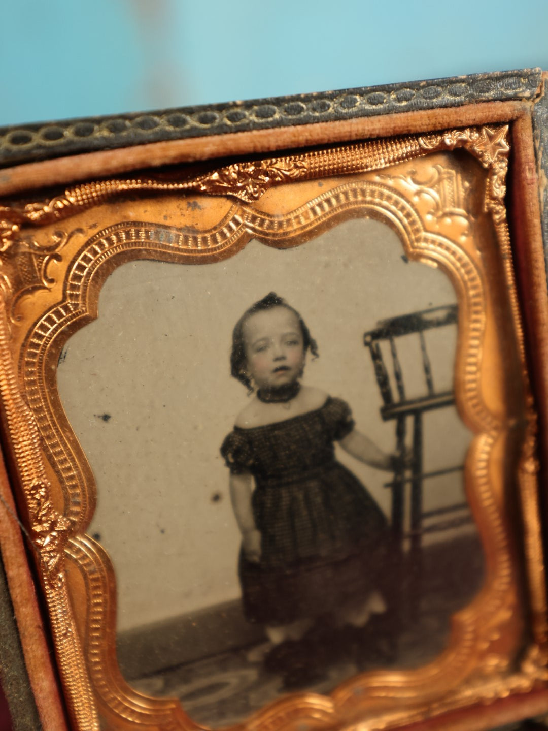 Lot 073 - Antique 1/6th Plate Ruby Ambrotype Of Young Girl Toddler Holding High Chair, Dark Off The Shoulders Dress, Heavy Wear To Case