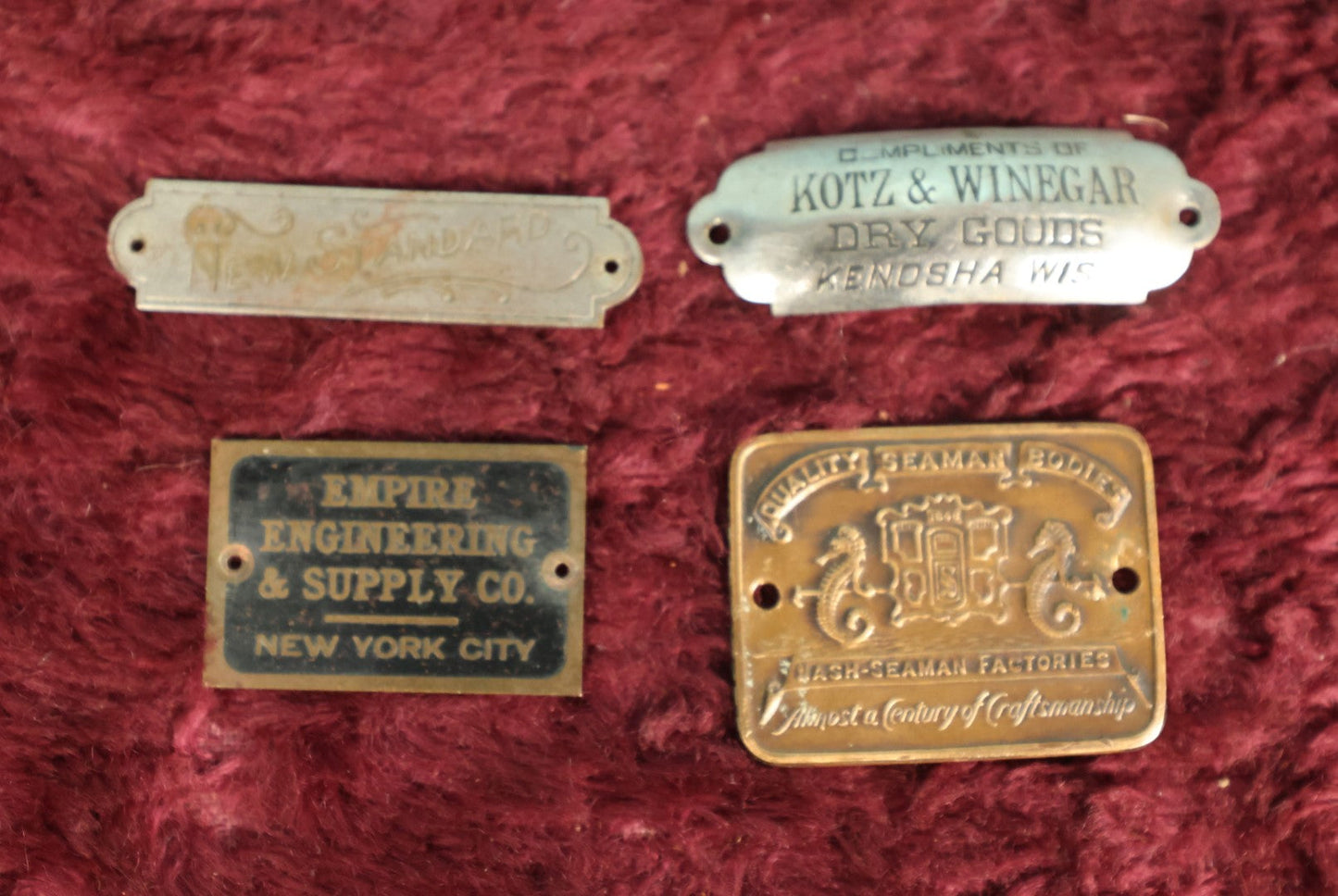 Lot 087 - Grouping Of Four Antique Metal Manufacturer's Badges, Kots & Winegar Dry Goods, Kenosha Wisconsin, Nash-Seaman Factories, Empire Engineering & Supply Co., New York City, New Standard