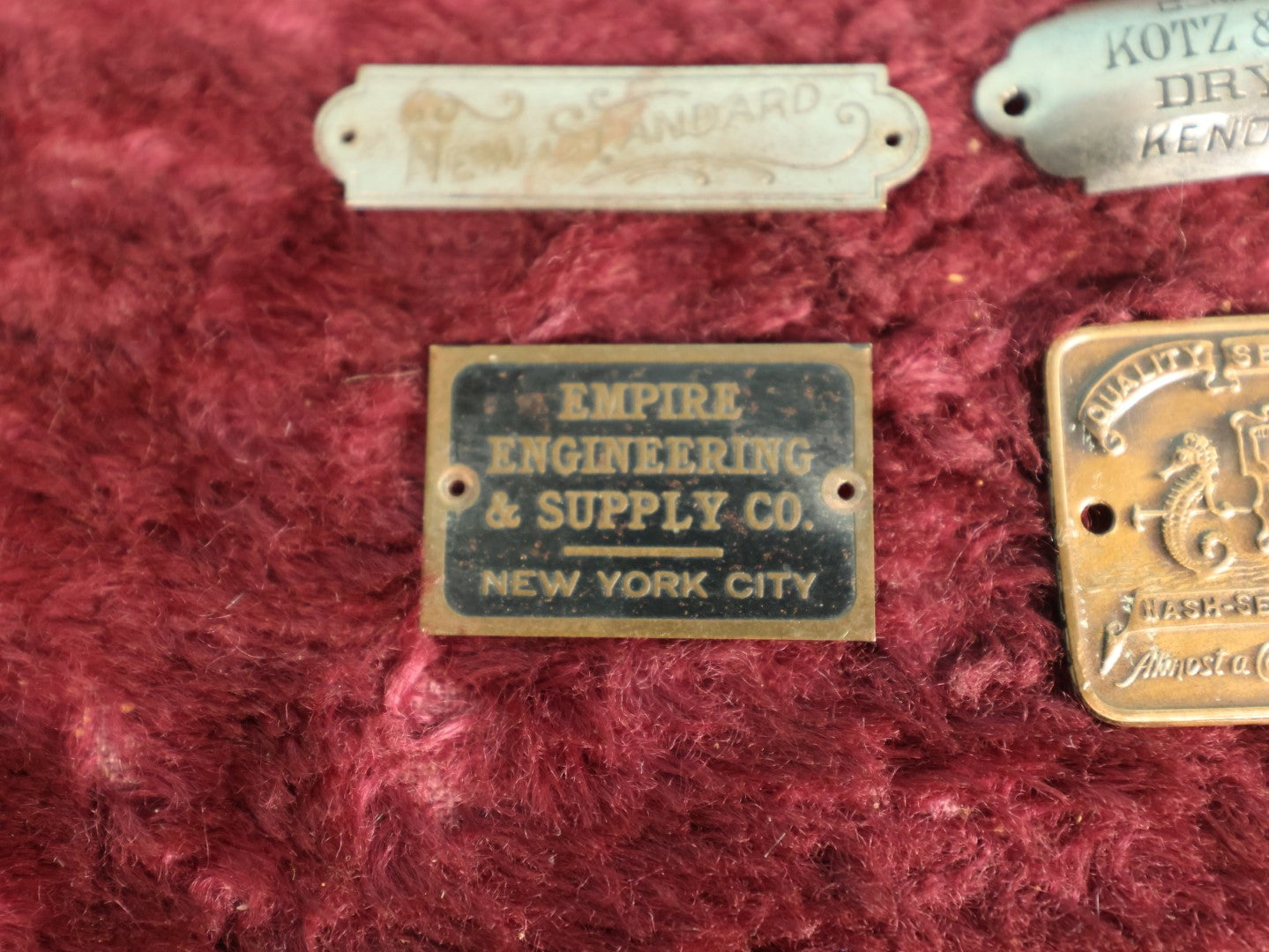 Lot 087 - Grouping Of Four Antique Metal Manufacturer's Badges, Kots & Winegar Dry Goods, Kenosha Wisconsin, Nash-Seaman Factories, Empire Engineering & Supply Co., New York City, New Standard