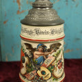 Lot 027 - Antique 1905 German Stein Having To Do With A Social Club, Featuring Winged Bat-Like Woman, Face Impaled Through Eye Ball, Augsburg Coat Of Arms, Signed Jos. (Joseph) Weber, Augsburg, With Markings