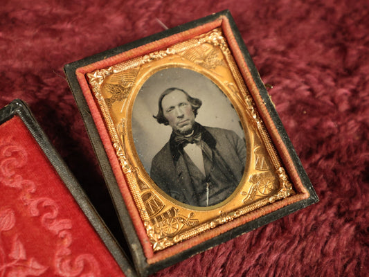 Lot 036 - Antique 1/9th Plate Ruby Ambrotype Photograph With Patriotic, Civil War Brass Mat With Eagle Carrying Flag, Drum, Canon, Rifle, Sword, Photo Of Man With Bowtie, Full Split Case