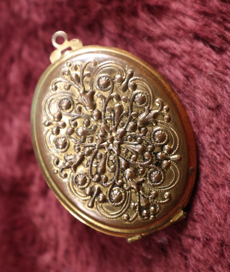 Lot 018 - Vintage Brass Locket With Grape Motif Containing Snapshot Photos Of A Young Boy And A Pretty Woman