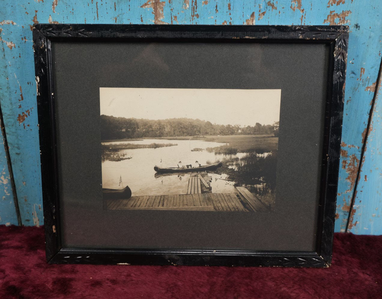 Lot 050 - Unusual Antique Framed Photo Of Two Women In A Canoe With A Skull And Crossbones / Jolly Roger Pillow, Boat Named Hiawatha, American Flag In Frame