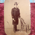 Lot 110 - Antique Tintype Of Young Boy In Long Peacoat, Tall Bowler Hat, Approximately 1/4 Plate