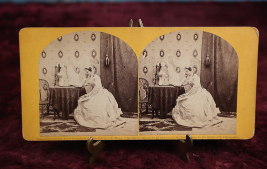 Lot 111 - Antique Spirit Photography Stereo Card, Woman At Table Looking At Photo Album With Spirit Behind Her, Dated 1869 By H.P. Moore, New Hampshire 