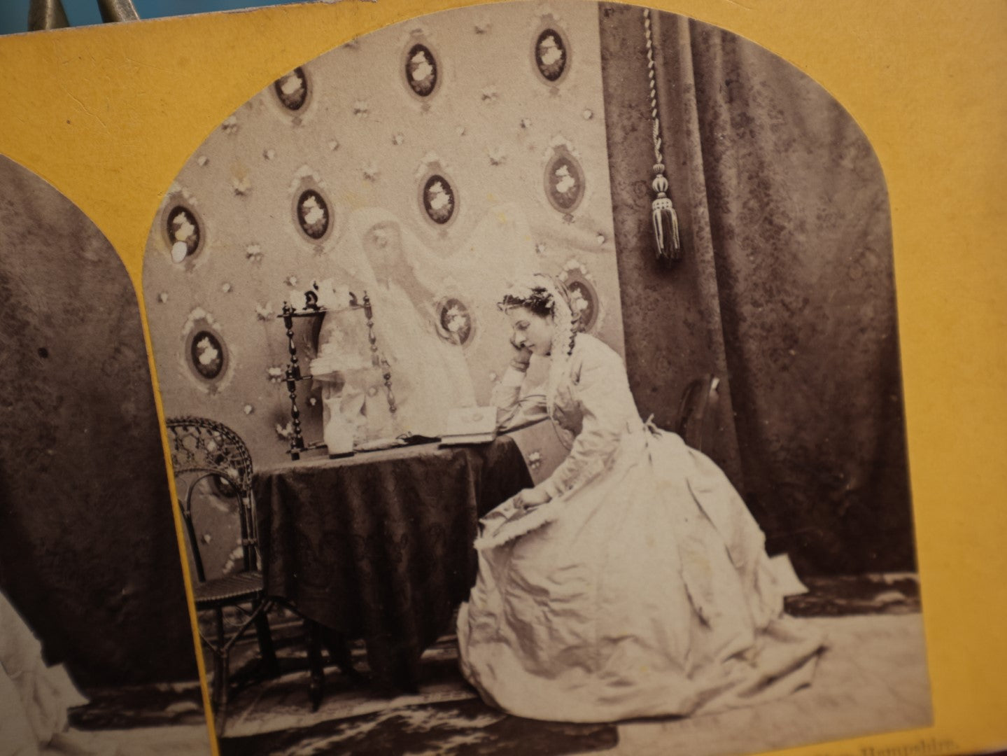 Lot 111 - Antique Spirit Photography Stereo Card, Woman At Table Looking At Photo Album With Spirit Behind Her, Dated 1869 By H.P. Moore, New Hampshire 