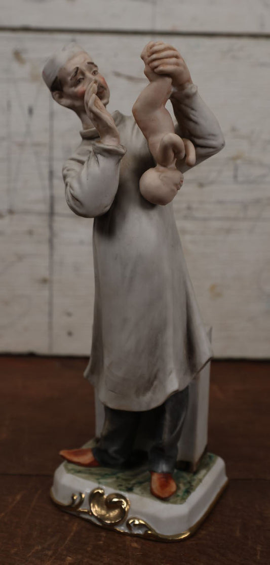 Lot 191 - Strange Vintage Porcelain Or Bisque Statue Of Doctor Holding Baby Upside Down, Marked Paride Benni, 44/28