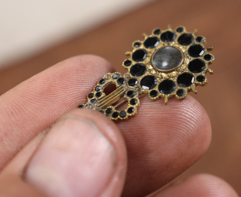 Lot 022 - Antique Brass Brooch With Black Stones And Woven Hair Under Glass Windows At Center, Note Scuff, Missing Stones