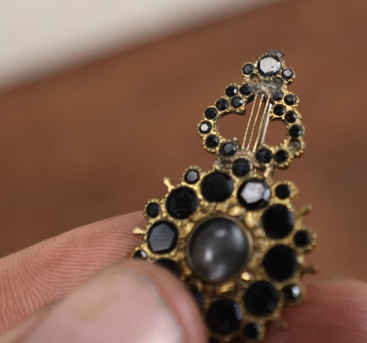 Lot 022 - Antique Brass Brooch With Black Stones And Woven Hair Under Glass Windows At Center, Note Scuff, Missing Stones