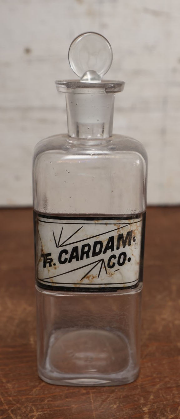 Lot 056 - Antique Apothecary Bottle With Glass Label, Tincture Of Cardamom, Note Crack In Label, Includes Stopper