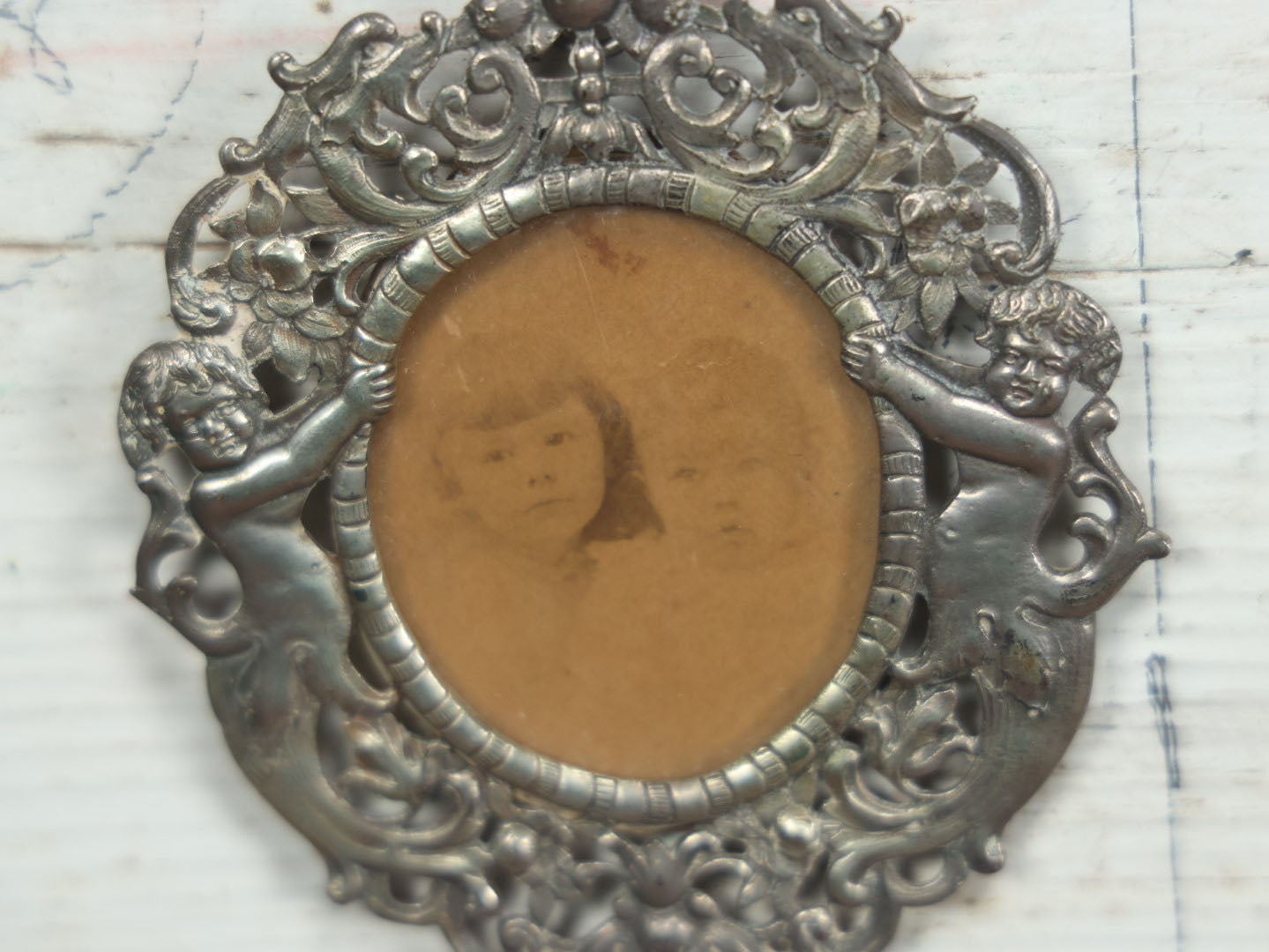 Lot 012 - Diminutive Antique Cast Silvertone Metal Frame With Cherubs On Sides, From Florence, Italy, By George W. Child, Containing An Identified Photo Of Lora F. Child And Donald Pratt, Circa 1895