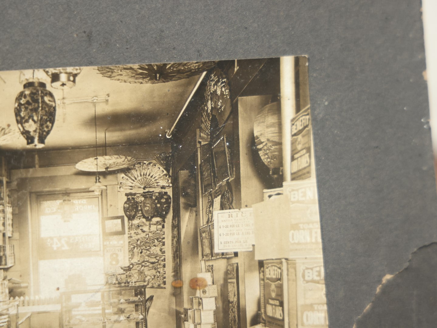 Lot 076 - Antique Boarded Occupational Photograph Of A Handsome Shopkeeper In A General Store, With Advertising, Chinese Lanterns With Tea Ads, And More, Note Bend In Corner