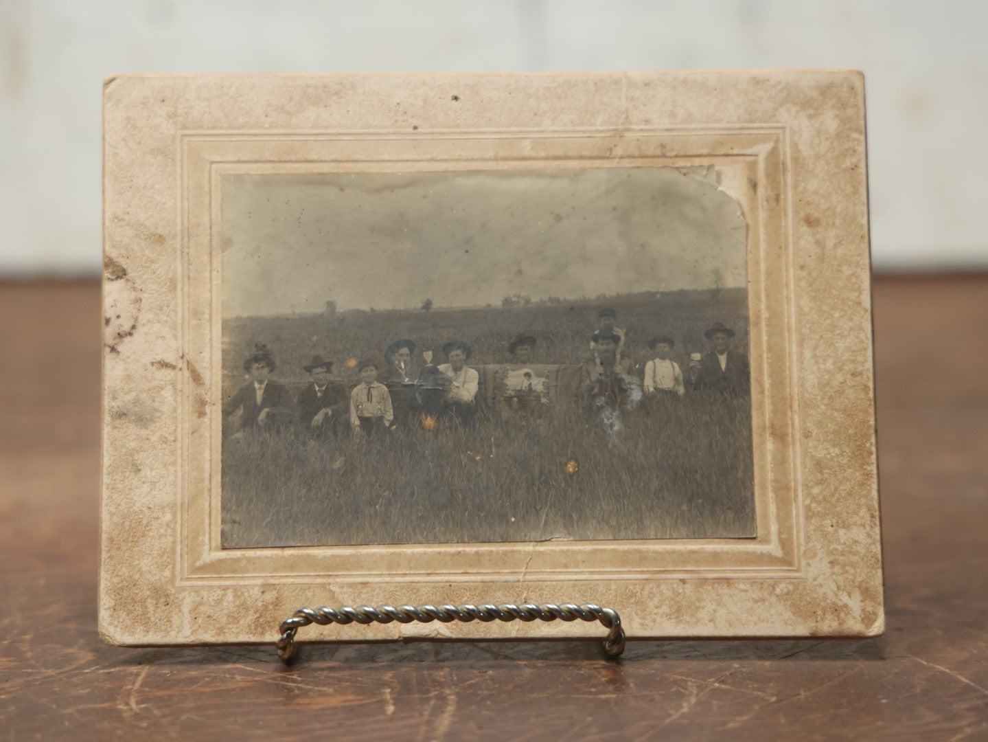 Lot 082 - Antique  Boarded Photograph Of A Group Of People In A Tall Grass Field, One Man Holding Pained Banner