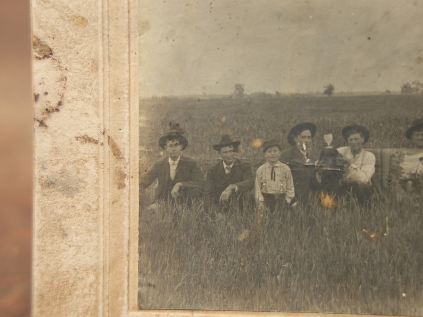 Lot 082 - Antique  Boarded Photograph Of A Group Of People In A Tall Grass Field, One Man Holding Pained Banner