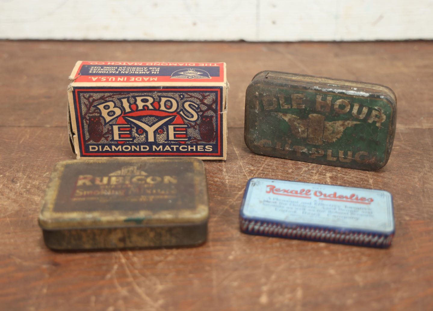 Lot 074 - Grouping Of Four Antique And Vintage Tins And Boxes - Birds Eye Matches, Idle Hour Cut Plug Tobacco, Rubicon Smoking Mixture, Rexall Orderlies Laxative