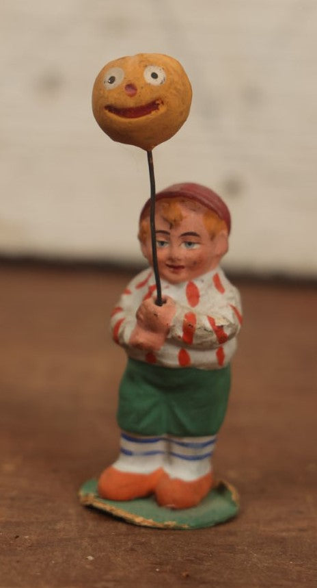 Lot 037 - Rare German Halloween Figurine, Papier Mache Or Bisque, Little Boy Holding Halloween Jack-O-Lantern J.O.L. Pumpkin Balloon