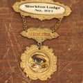 Lot 039 - Antique Odd Fellows I.O.O.F. Metal Member Badge, Stockton Lodge No. 81 With All Seeing Eye, Three Links, F.L.T., By The M.C. Lilley & Co., Columbus, Ohio