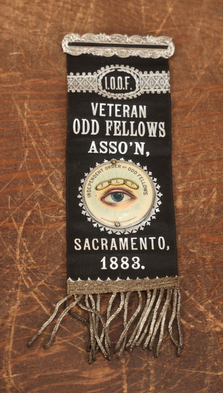 Lot 040 - Antique Odd Fellows I.O.O.F. Veteran Odd Fellows Association Ribbon And Badge, Sacramento, 1883, With All Seeing Eye, Three Links, F.L.T., By The Whitehead & Hoag Co., Newark, New Jersey