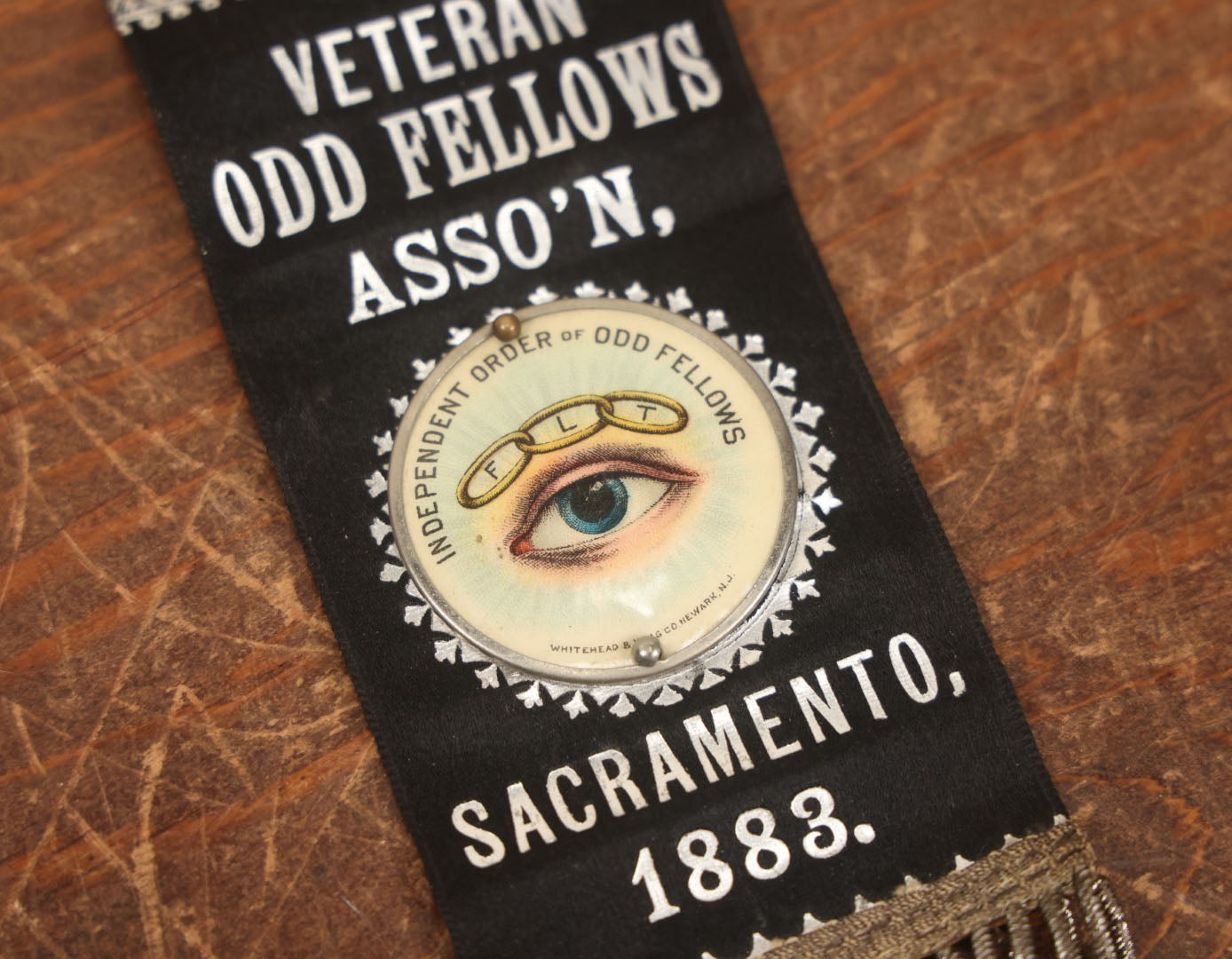 Lot 040 - Antique Odd Fellows I.O.O.F. Veteran Odd Fellows Association Ribbon And Badge, Sacramento, 1883, With All Seeing Eye, Three Links, F.L.T., By The Whitehead & Hoag Co., Newark, New Jersey