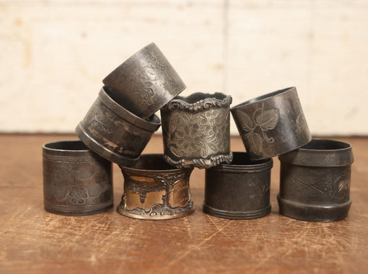 Lot 046 - Grouping Of Eight Antique And Vintage Silverplate Napkin Rings, Ornate Designs, Florals, Monograms, And More, One From U.S. Capitol