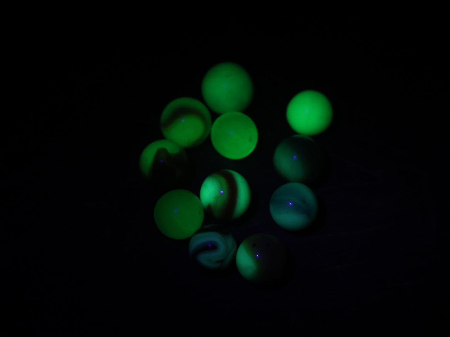 Lot 079 - Grouping Of 11 Uranium Glass And Other U.V. Blacklight Reactive Vintage And Antique Marbles