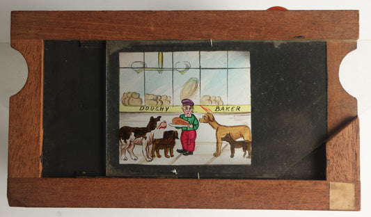 Lot 041 - Antique Hand Painted Animated Magic Lantern Motion Slide, Young Boy With Chicken Outside Bakery Surrounded By Dogs, Dogs Slide In From Both Sides