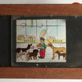 Lot 041 - Antique Hand Painted Animated Magic Lantern Motion Slide, Young Boy With Chicken Outside Bakery Surrounded By Dogs, Dogs Slide In From Both Sides