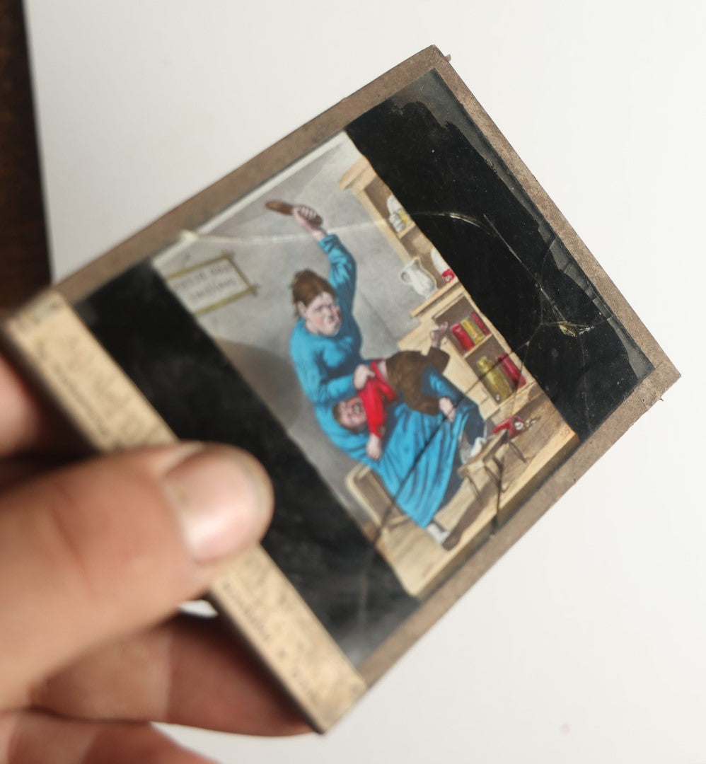 Lot 046 - Antique Hand Colored Magic Lantern Slide, Boy Receiving Spanking From Mother, Note Heavy Damage And Cracking, Theo J. Harbach Manufacturer, Philadelphia, Pennsylvania