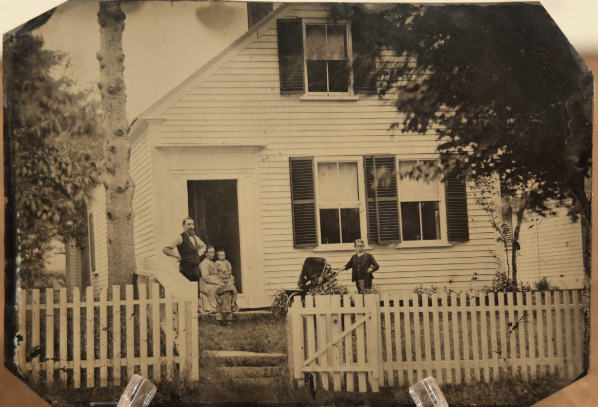 Lot 012 - Large Plate Exterior Tintype Of A Family Outside Of Their Home, Two Adults And Three Children, With White Picket Fence, 6-7/8" x 4-7/8"