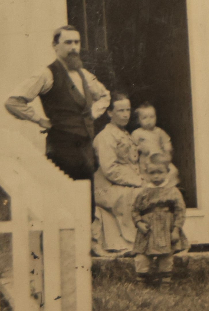 Lot 012 - Large Plate Exterior Tintype Of A Family Outside Of Their Home, Two Adults And Three Children, With White Picket Fence, 6-7/8" x 4-7/8"