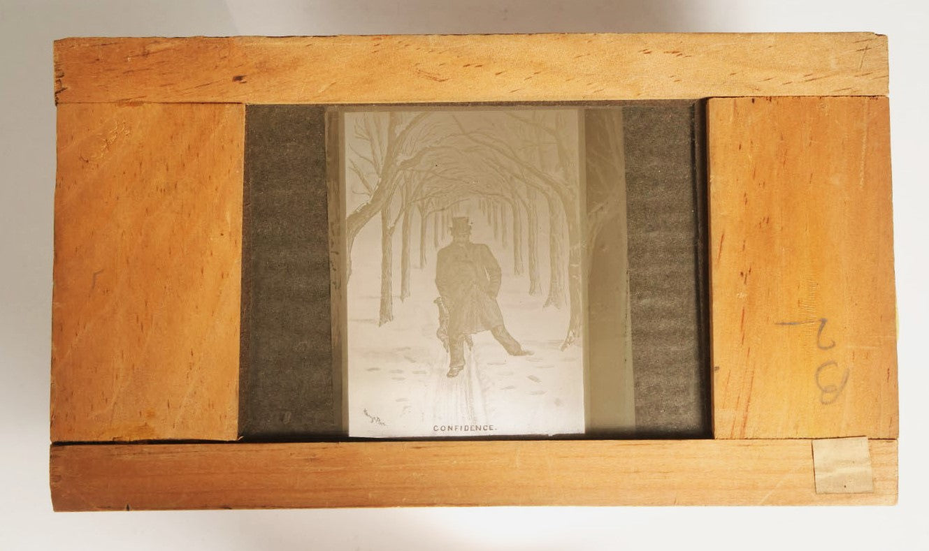 Lot 043 - Antique Hand Painted Magic Lantern Slide, Man About To Be Knocked Over By Children On Sled, Titled "Confidence," Artist Signed By Harry Platt 