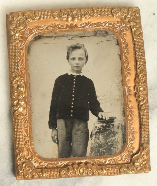 Lot 043 - Antique 1/9Th Plate Tintype In Brass Mat Of A Young Boy Leaning On A Table With Books Or Photos