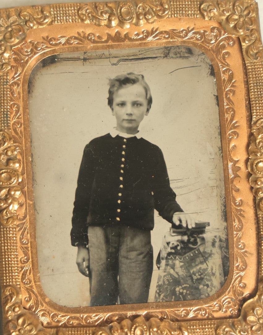 Lot 043 - Antique 1/9th Plate Tintype In Brass Mat Of A Young Boy Leaning On A Table With Books Or Photos