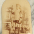 Lot 046 - Antique Unframed Bubble Glass Mounted Photo Of A Young Girl Leaning An Easel With Artwork, Identified As Emily Babb