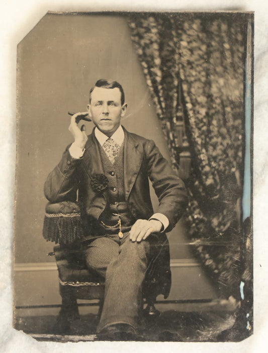 Lot 096 - Single Antique Tintype Photograph, Middle Aged Man Smoking A Cigar, With Watch Chain, Crossed Legs, Black Bow On Jacket