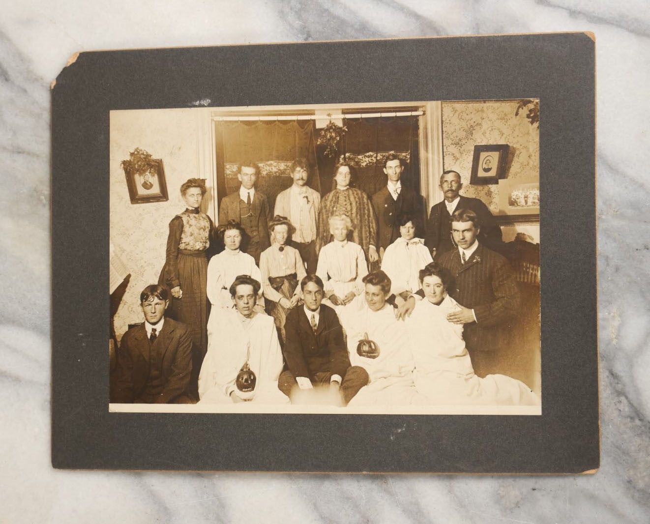 Lot 022 - Antique Turn Of The Century Boarded Photograph Of A Halloween Party, Including Two Women Holding Jack-O-Lantern Pumpkins, Pencil Identification On Back, Approximately 8-7/8" x 7"