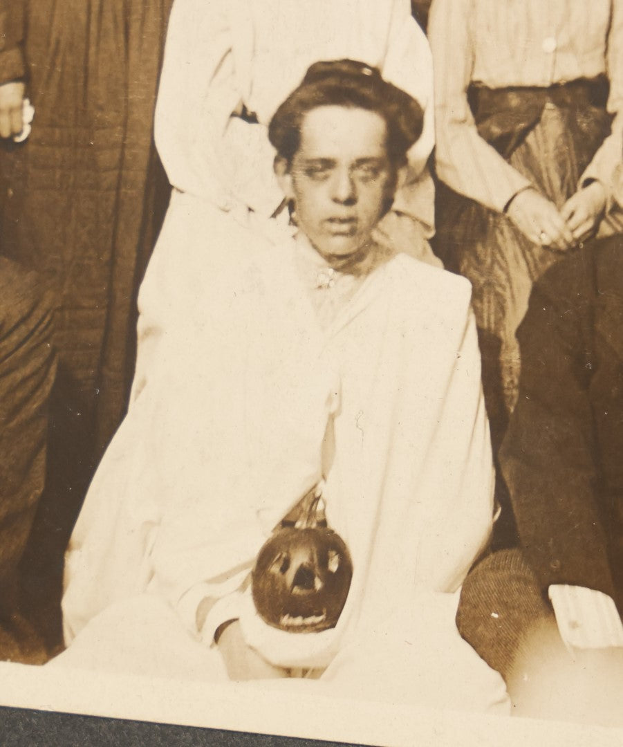 Lot 022 - Antique Turn Of The Century Boarded Photograph Of A Halloween Party, Including Two Women Holding Jack-O-Lantern Pumpkins, Pencil Identification On Back, Approximately 8-7/8" x 7"