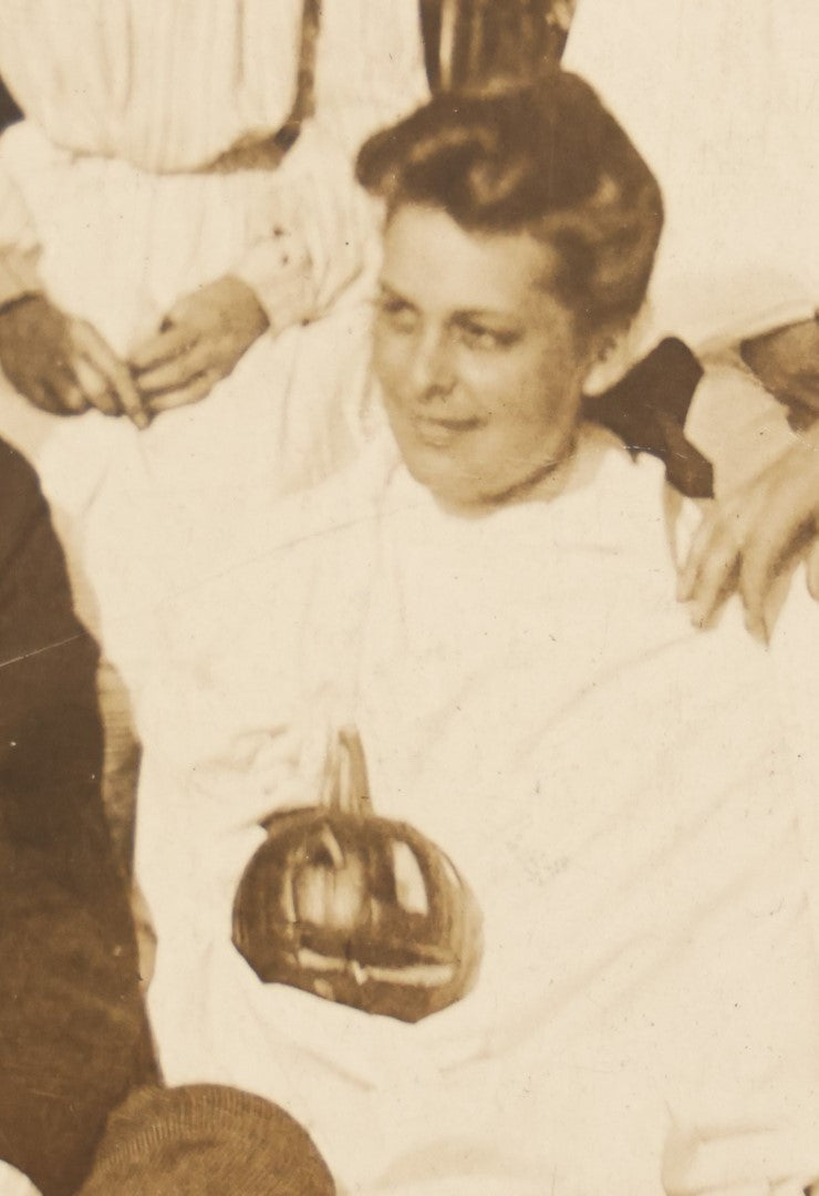 Lot 022 - Antique Turn Of The Century Boarded Photograph Of A Halloween Party, Including Two Women Holding Jack-O-Lantern Pumpkins, Pencil Identification On Back, Approximately 8-7/8" x 7"