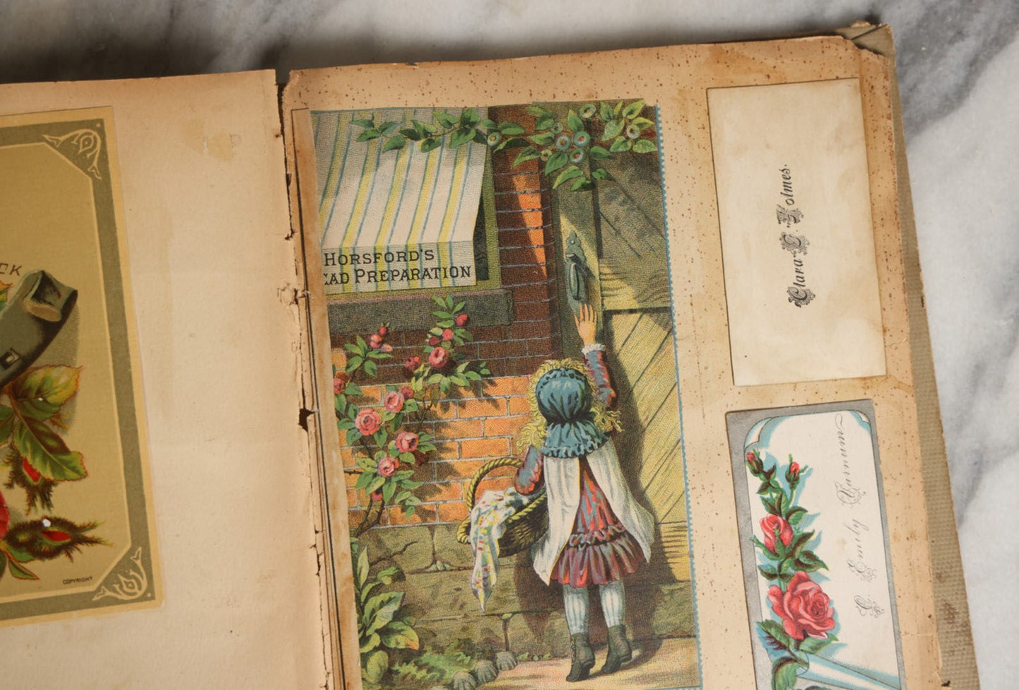 Lot 029 - Antique Victorian Trade Card Scrapbook Album With Two Girls And Puppy On Cover, Containing Many Scraps Including Rat Poison, Calling Card, Frogs, And More