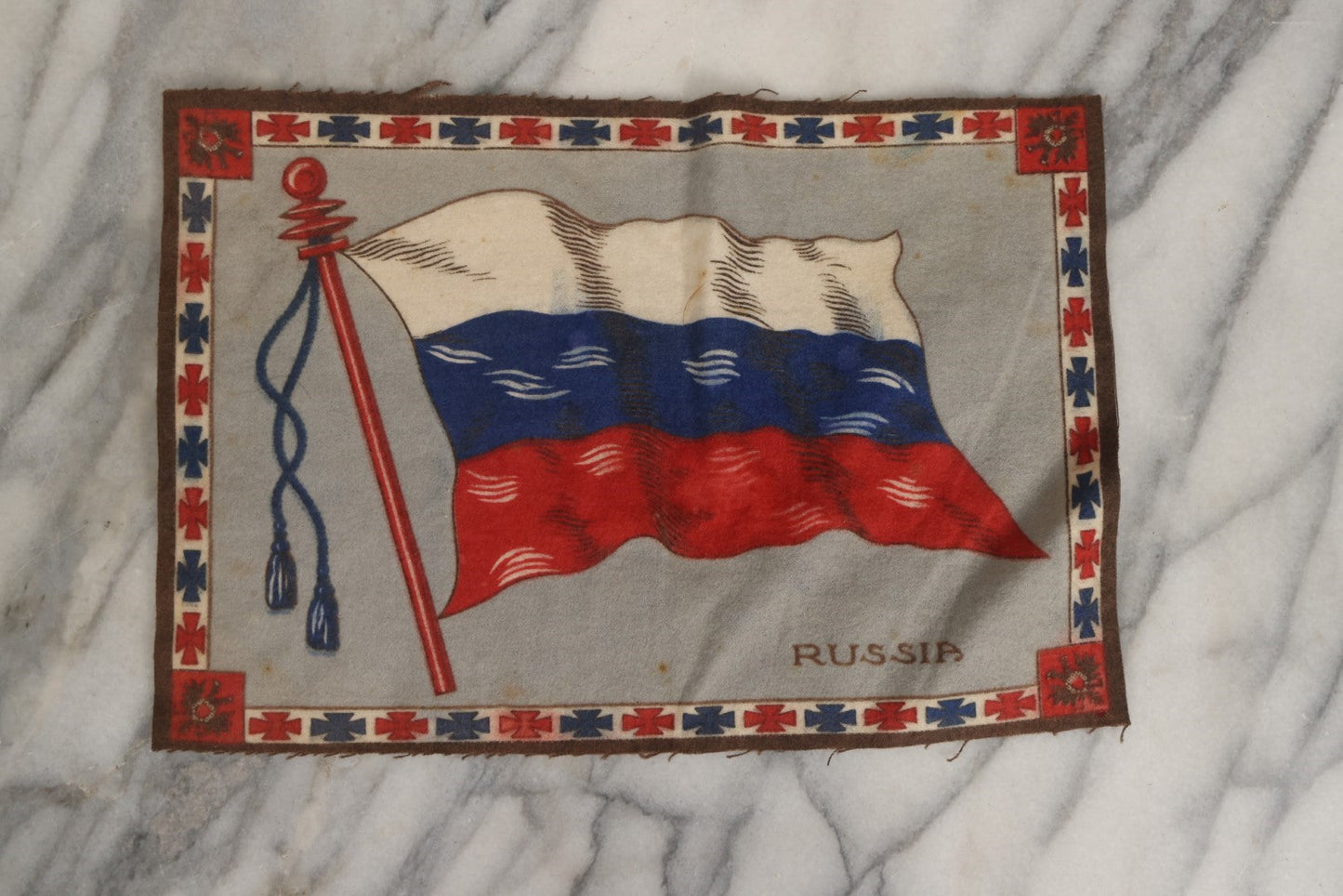 Lot 039 - Grouping Of Ten Antique Tobacco Felt Flags, Including Japan, 2 x Russia, Italy, Mexico, Cuba, Belgium, Netherlands, Austria-Hungary, And The Union Jack, Various Wear.