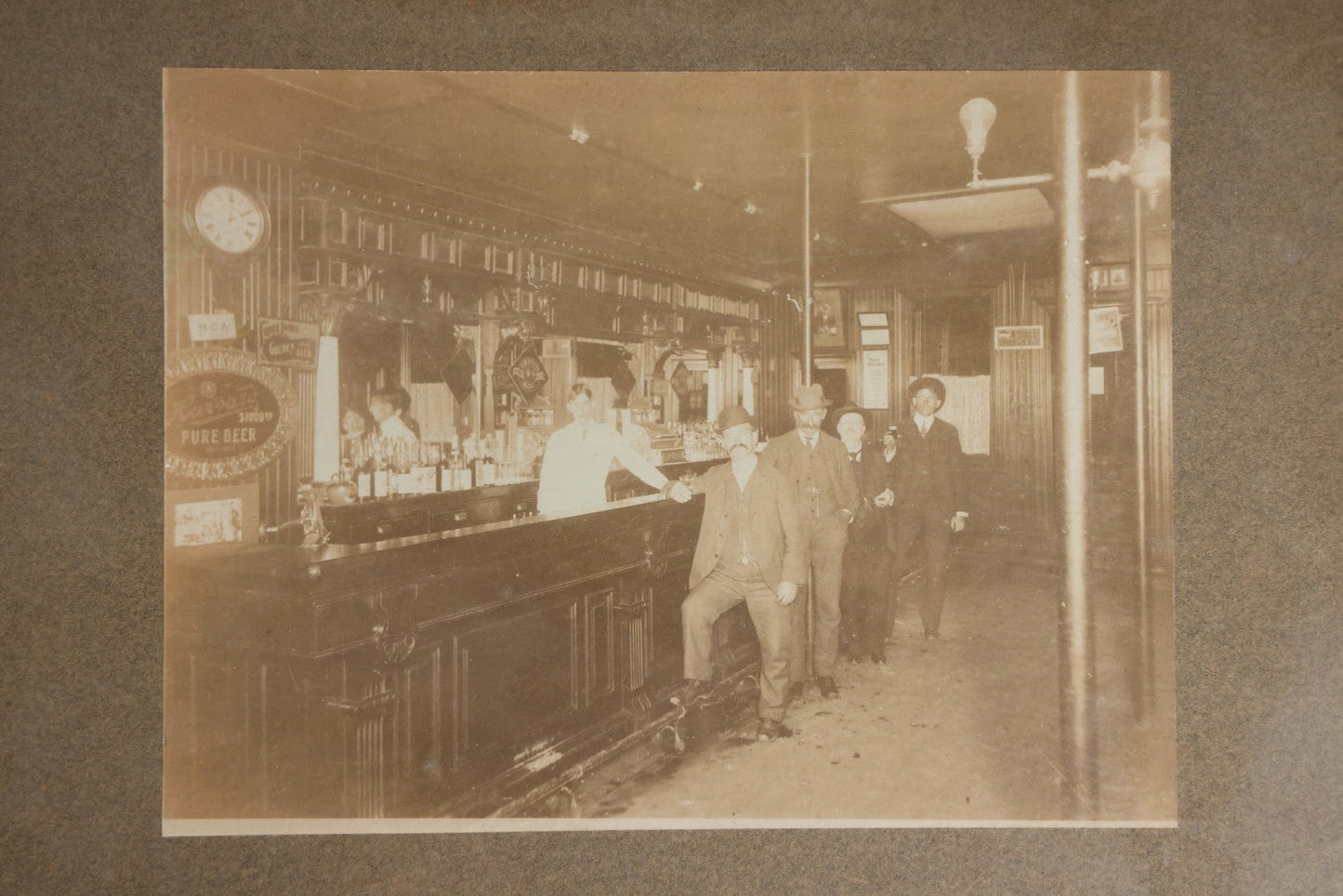 Lot 050 - Antique Framed Boarded Photograph Of A Bar Room, Four Men At The Bar With Barkeeper, Beer Advertisements, Etc