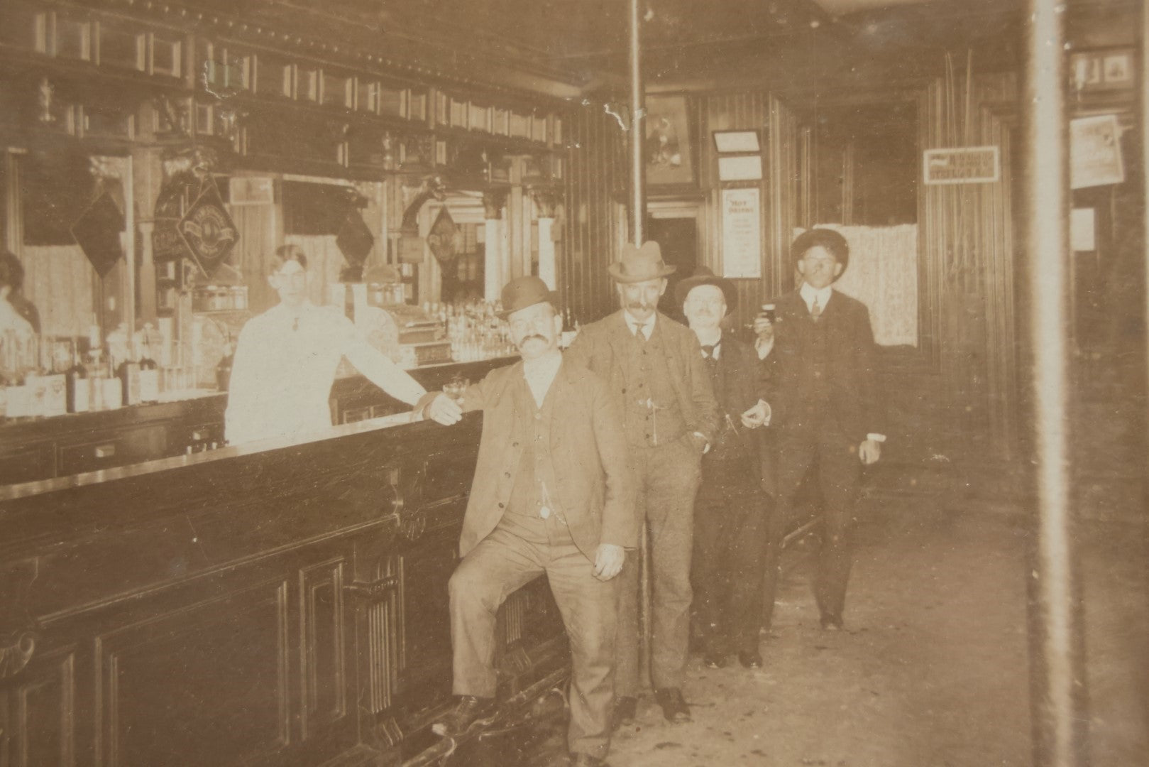 Lot 050 - Antique Framed Boarded Photograph Of A Bar Room, Four Men At The Bar With Barkeeper, Beer Advertisements, Etc