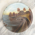 Lot 039 - Antique Hand Painted Wooden Plate, Landscape Scene With A Bridge Over A River, Foliage, With Plate Hanger