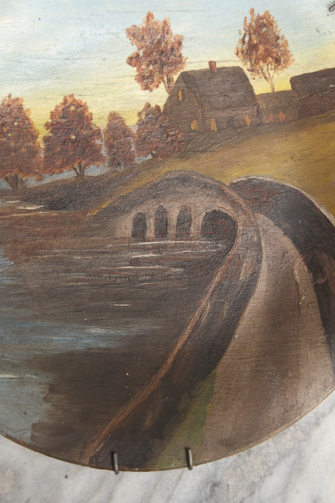 Lot 039 - Antique Hand Painted Wooden Plate, Landscape Scene With A Bridge Over A River, Foliage, With Plate Hanger