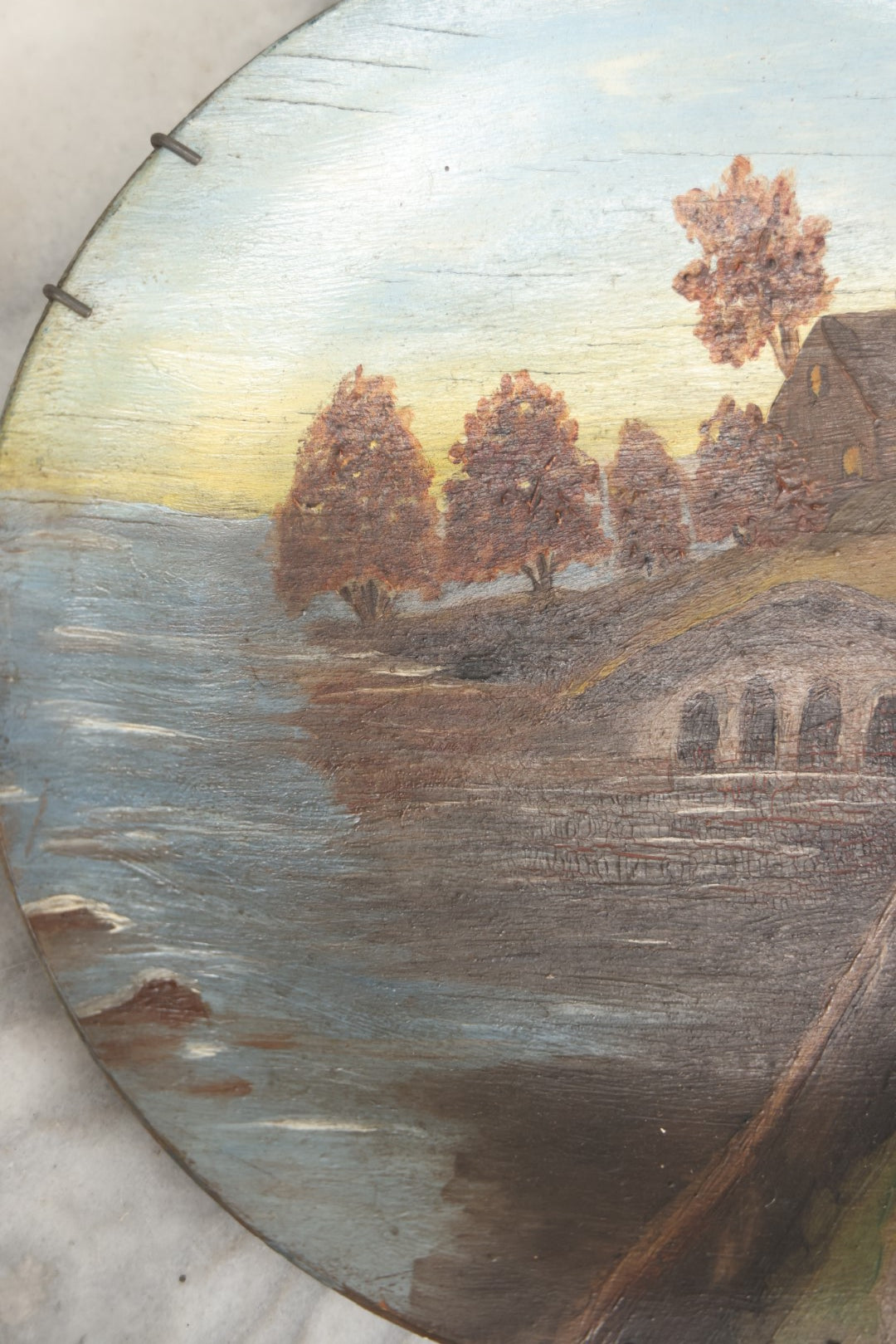 Lot 039 - Antique Hand Painted Wooden Plate, Landscape Scene With A Bridge Over A River, Foliage, With Plate Hanger