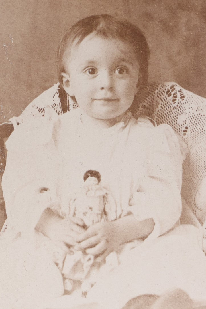 Lot 055 - Antique Cabinet Card Photograph Of A Toddler, Young Boy Or Girl, Holding Doll, With Nervous Smile, Wide Eyes, L.P. Ogden, Successor To B.F. Ogden Photographer, Massachusetts, New York