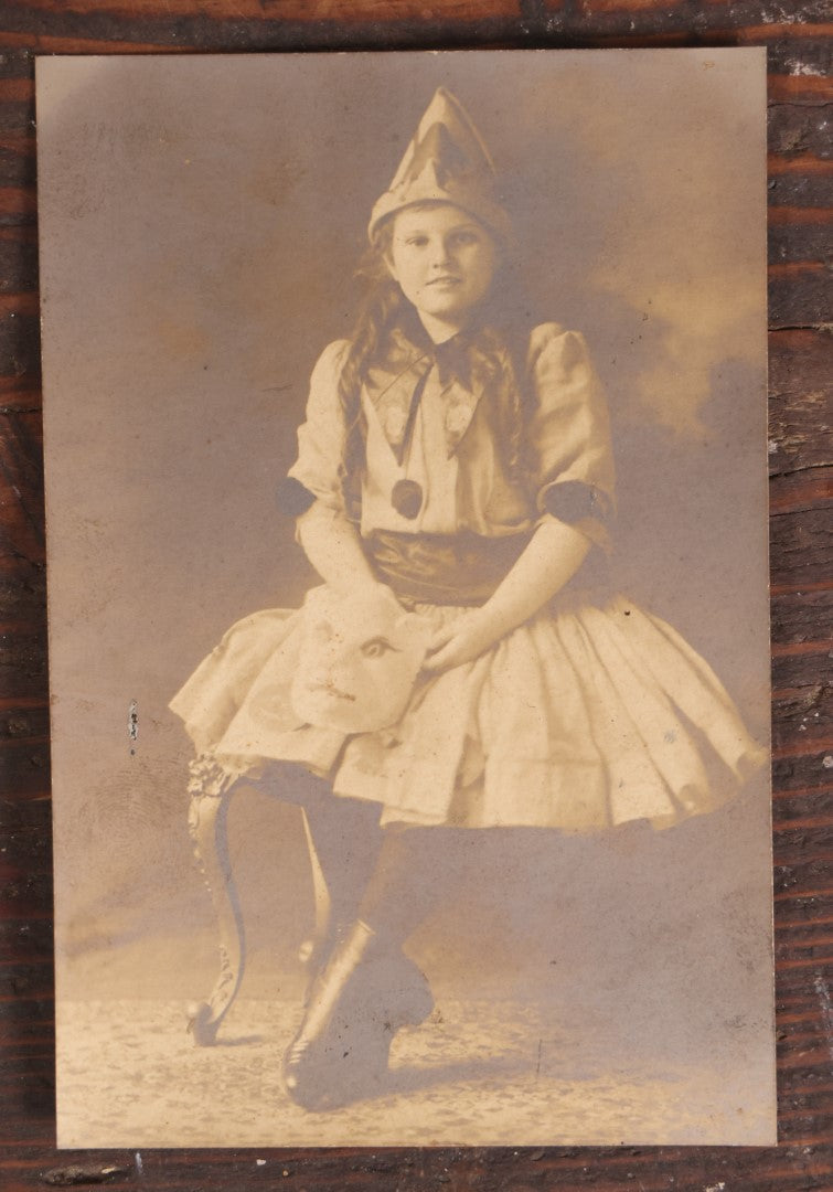 Lot 061 - Antique Photo Of A Young Girl In A Halloween Costume, Black Cats On Hat, Pumpkin Jack-O-Lanterns On Her Skirt, Holding An Animal Mask