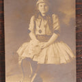 Lot 061 - Antique Photo Of A Young Girl In A Halloween Costume, Black Cats On Hat, Pumpkin Jack-O-Lanterns On Her Skirt, Holding An Animal Mask